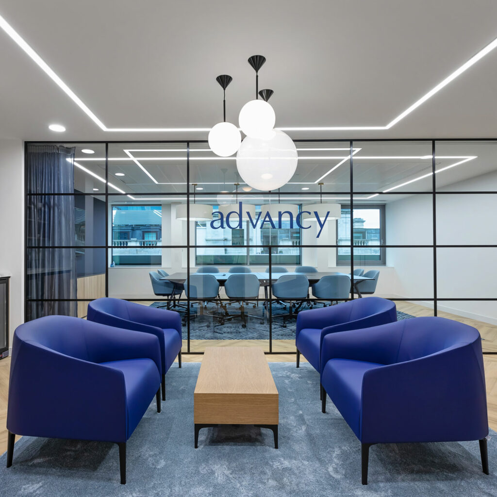Advancy reception area with blue seating and glass dividers created by office design compam Arke