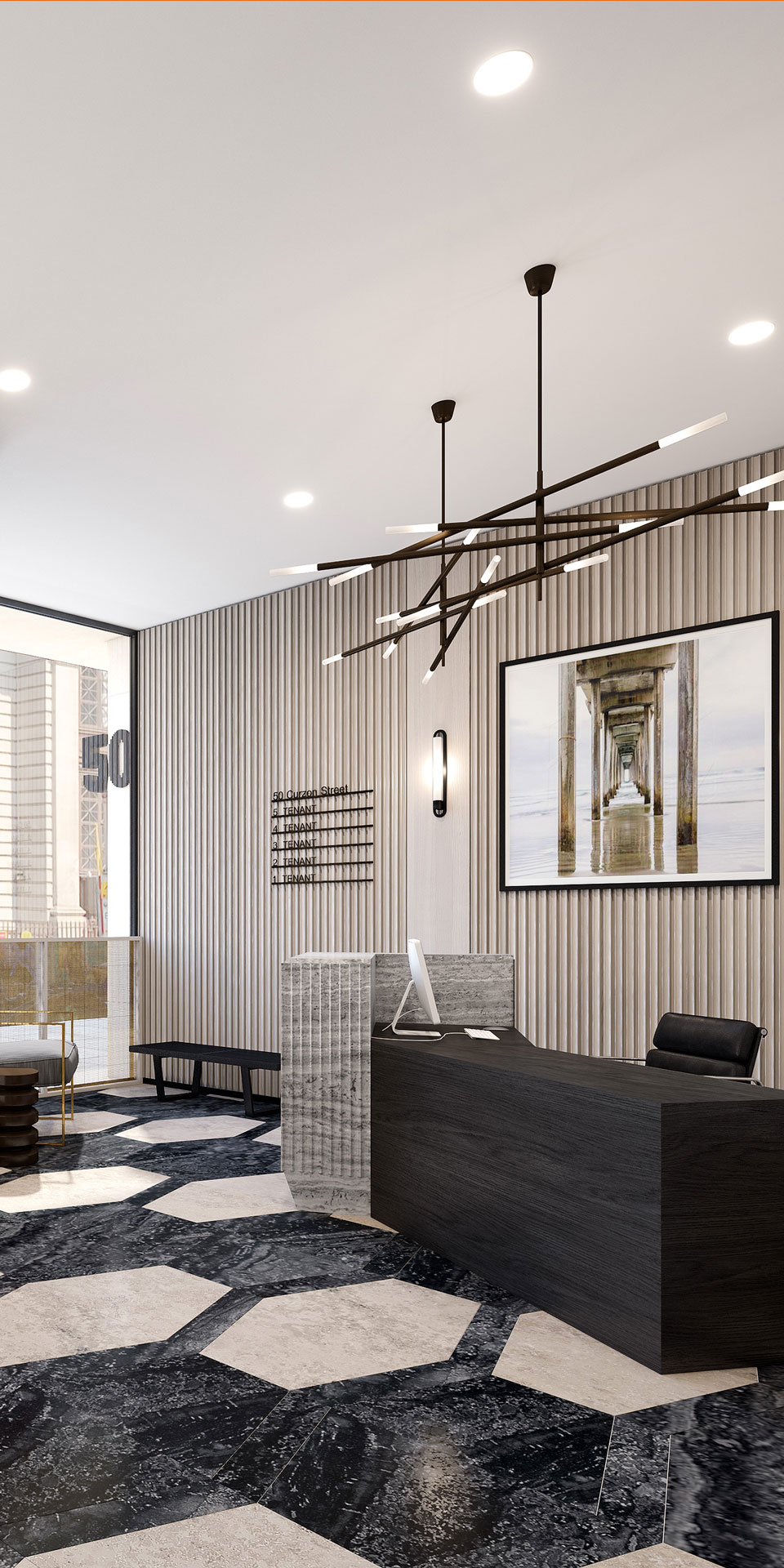 Reception area with wood panelling, geometric patterned floor and a black welcome desk